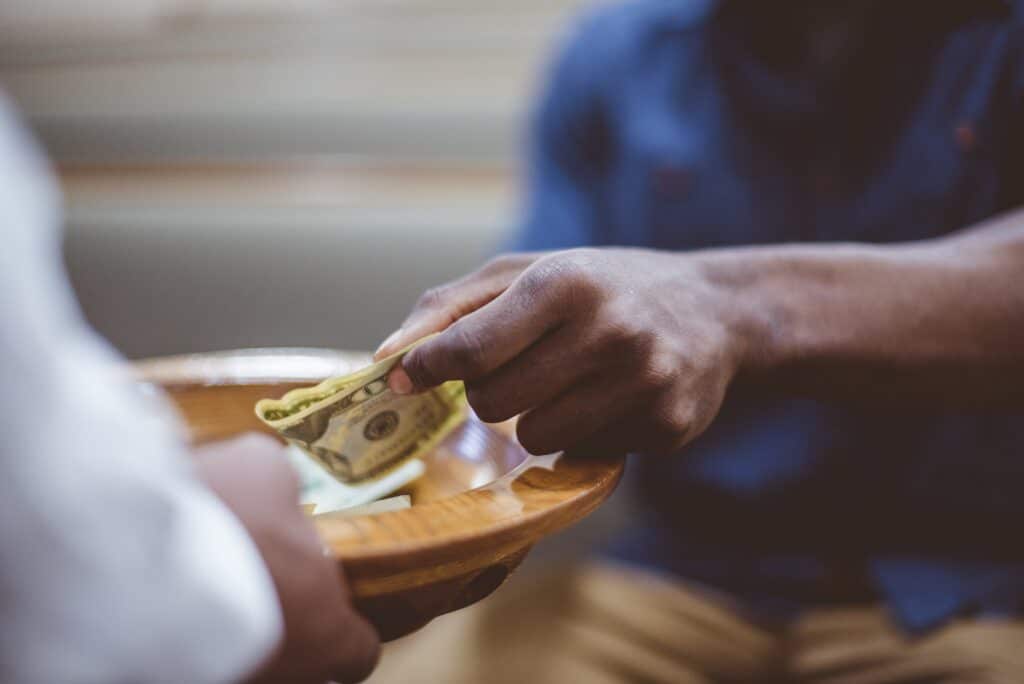 Closeup shot of a male donating money for church with a blurred background